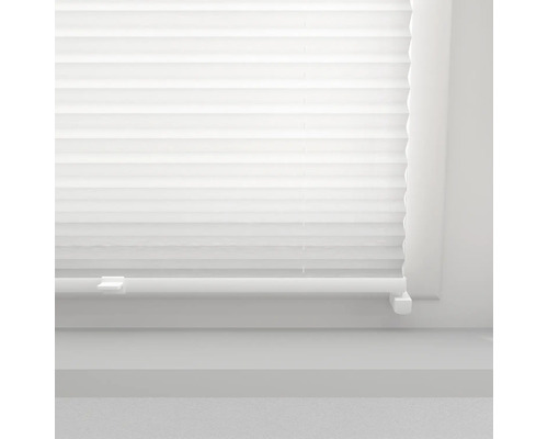 Närbild av en vit plisségardin vid ett fönster