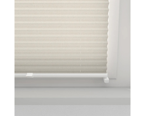 Beige plisségardin på ett fönster