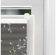 Närbild av en grå plisségardin med bladmönster på ett fönster