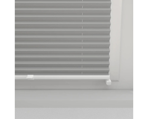 Närbild av en plisségardin på fönstret