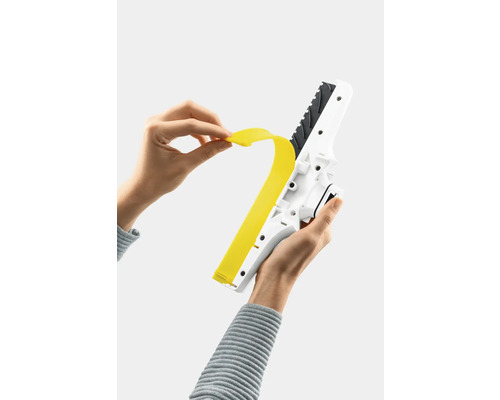 En person byter gummiläppen på en fönsterskrapa.