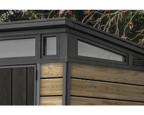 Detaljvy av ett trädgårdshus med fönster och träpanel.