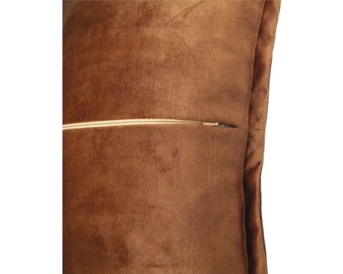 Detaljvy av en brun prydnadskudde med dragkedja