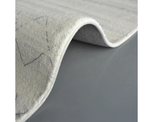 Detaljvy av en ljus matta med geometriskt mönster