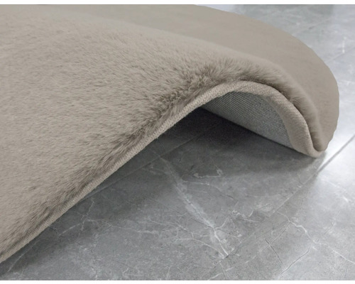 Detaljvy av en beige matta med hög lugg