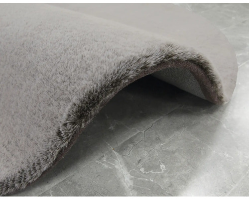 Detaljvy av en rund, ljusfärgad matta med lugg