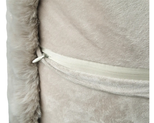 Detalj av en kudde med dragkedja och kant av fuskpäls