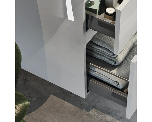 Detaljvy av ett badrumsskåp med öppna lådor och handdukar