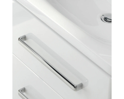 Detaljvy av ett badrumsskåp med handfat och lådor med handtag