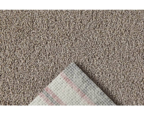 Närbild av en beige matta med textilbaksida