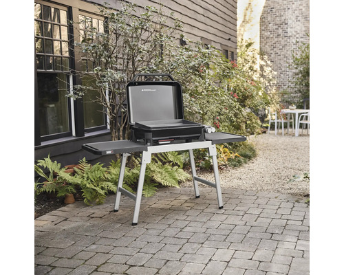 Weber gasolgrill med öppet lock på en terrass