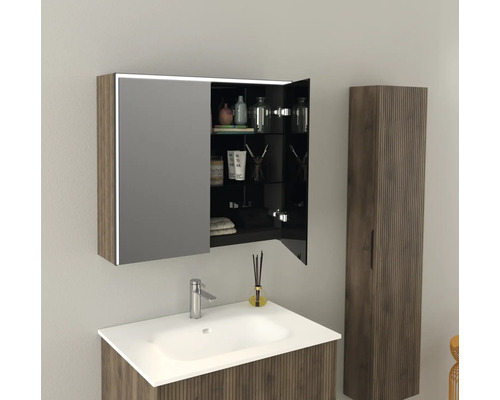 Modernt badrum med tvättställ, spegelskåp och högskåp i träimitation.