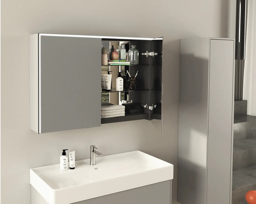 Badrum med handfat, armatur och öppet spegelskåp med belysning