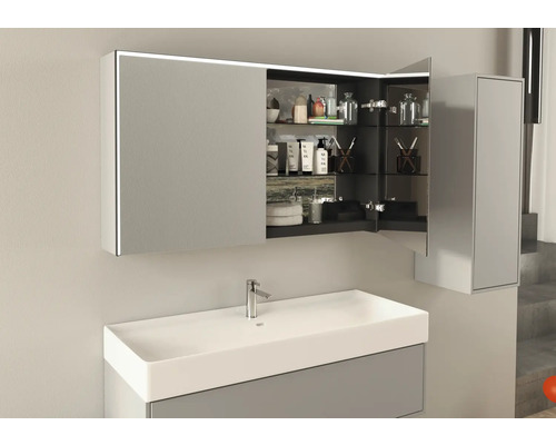 Öppet spegelskåp med belysning ovanför ett handfat i ett badrum