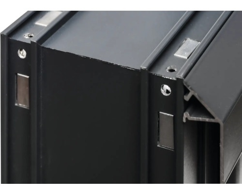 Detaljvy av en svart aluminiumprofil med skruvhål och magneter