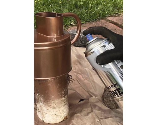 En person sprayar en kanna med en sprayburk.