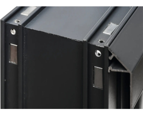 Detaljvy av en svart aluminiumprofil med skruvhål och magneter