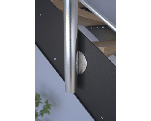 Detaljvy av en trappa med rostfritt stålräcke och svarta sidelement