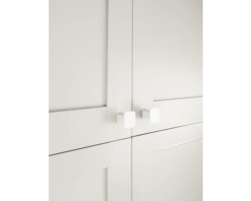 Detaljbild av vita skåpdörrar med fyrkantiga handtag