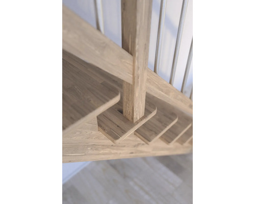 Detaljvy av en trätrappa med trappstolpar och ledstångspinnar.