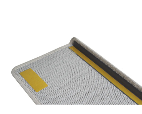 Detaljvy av en grå trappstegsmatta med tejp för fastsättning.