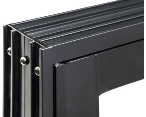 Detaljvy av en svart aluminiumfönsterkarm med skruvar