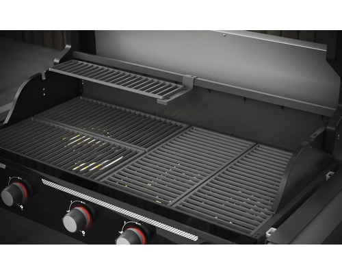 Inre vy av en gasgrill med grillgaller och värmegaller