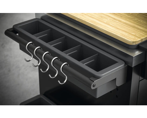 Detaljvy av grillstation med behållare för grilltillbehör och metallkrokar