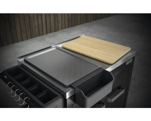 Detaljvy av en grillvagn med förvaringsyta och skärbräda