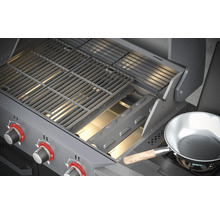 Detaljvy av en gasolgrill med grillgaller och en kastrull