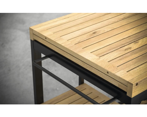 Detaljvy av en serveringsvagn med arbetsyta i trä och svart metallram.