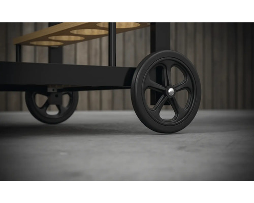 Detaljbild av en serveringsvagn med svarta hjul.