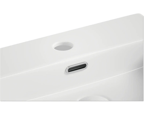 Detaljvy av ett tvättställ med kranhål och överfyllnadsskydd