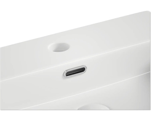 Detaljvy av ett vitt tvättställ med överfyllnadsskydd