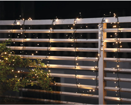 Dekorativ ljusslinga på ett trädgårdsstaket