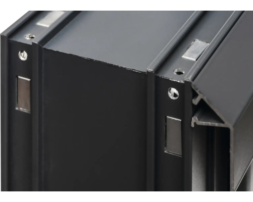 Detaljvy av en svart aluminiumram med magneter och skruvhål