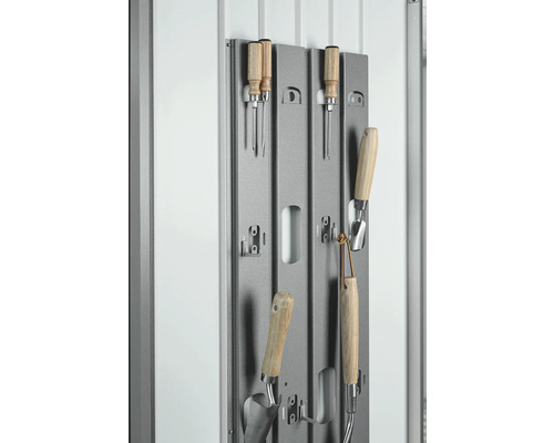 Trädgårdsverktyg på ett grått metallfäste för förvaring.