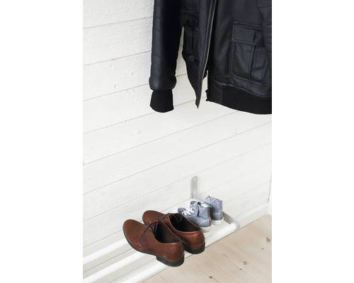 Svart jacka hänger ovanför skoställ med skor