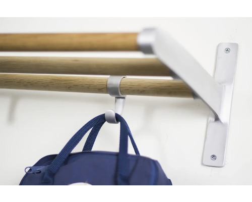 Garderob med tre trästänger och en blå väska