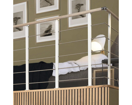 Interiörbild av en räcke med horisontella stålvajrar, ett träräcke och vita vertikala stöd