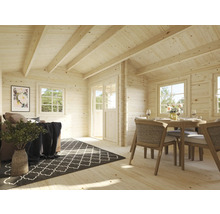 Interiör av ett trähus med vardagsrumsdel och matplats