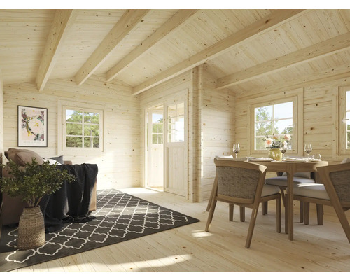 Interiör av ett trähus med vardagsrumsdel och matplats