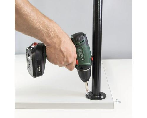 En person fäster en metallstolpe på en vit yta med en sladdlös skruvdragare.