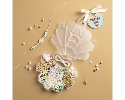 Pärlmix i en snäckformad låda med diverse pärlor, hängen och en snodd för smyckestillverkning