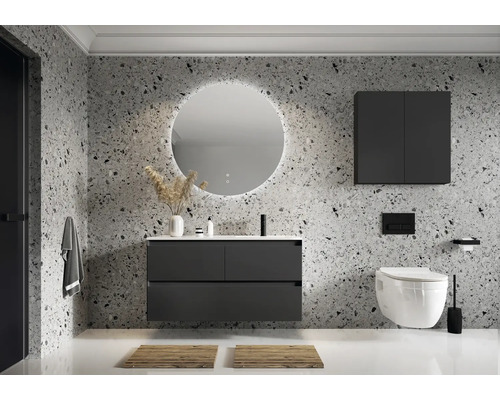 Modernt badrum med tvättställ, spegel, hängande skåp och toalett framför en mönstrad vägg