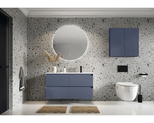 Modernt badrum med blått tvättställ, spegelskåp och rund spegel med belysning