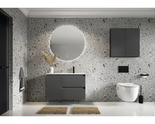 Modernt badrum med tvättställsskåp, spegelskåp och vägghängd toalett framför en mönstrad vägg