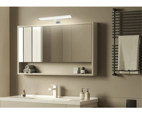 Modernt badrum med spegelskåp, handfat, handdukstork och minimalistisk design