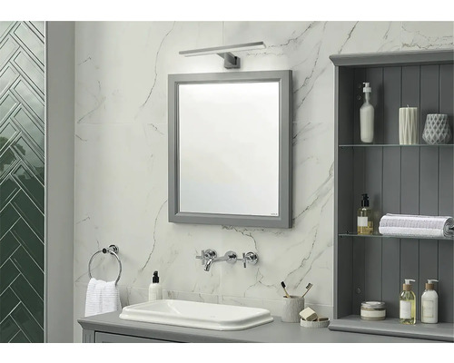 Badrum med spegel, handfat, armatur och badrumsskåp