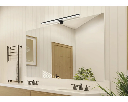 Ljust badrum med spegel, handfat, kranar, handdukstork och belysning